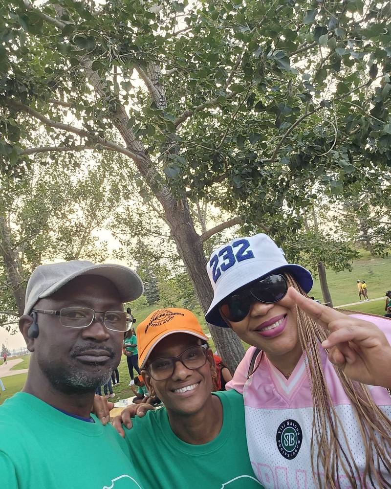 Three smiling picnic-goers taking a selfie, two in green SALDAC T-shirts