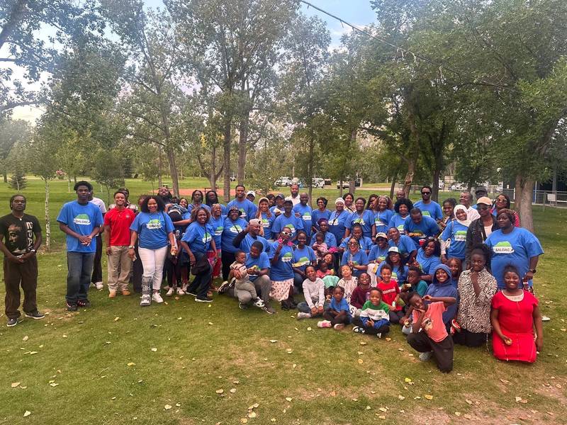 A large group of SALDAC members and families in blue T-shirts at an earlier Picnic in the Park